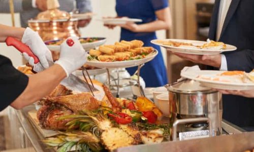 Cropped imaged of waiter cutting turkey for guests